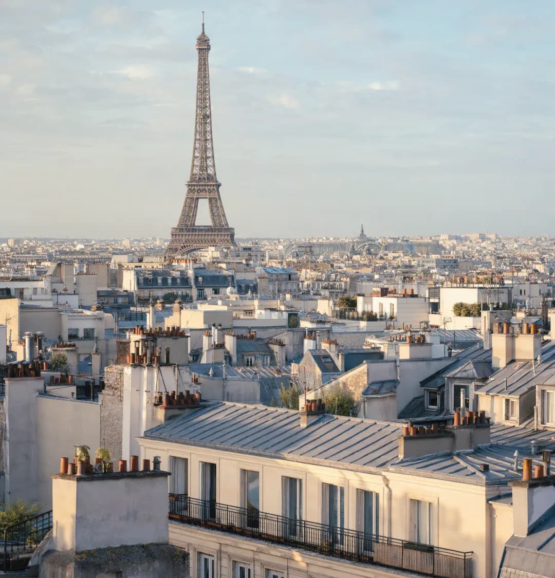 Paris rooftops and the Eiffel Tower, with a phone showing a verification code