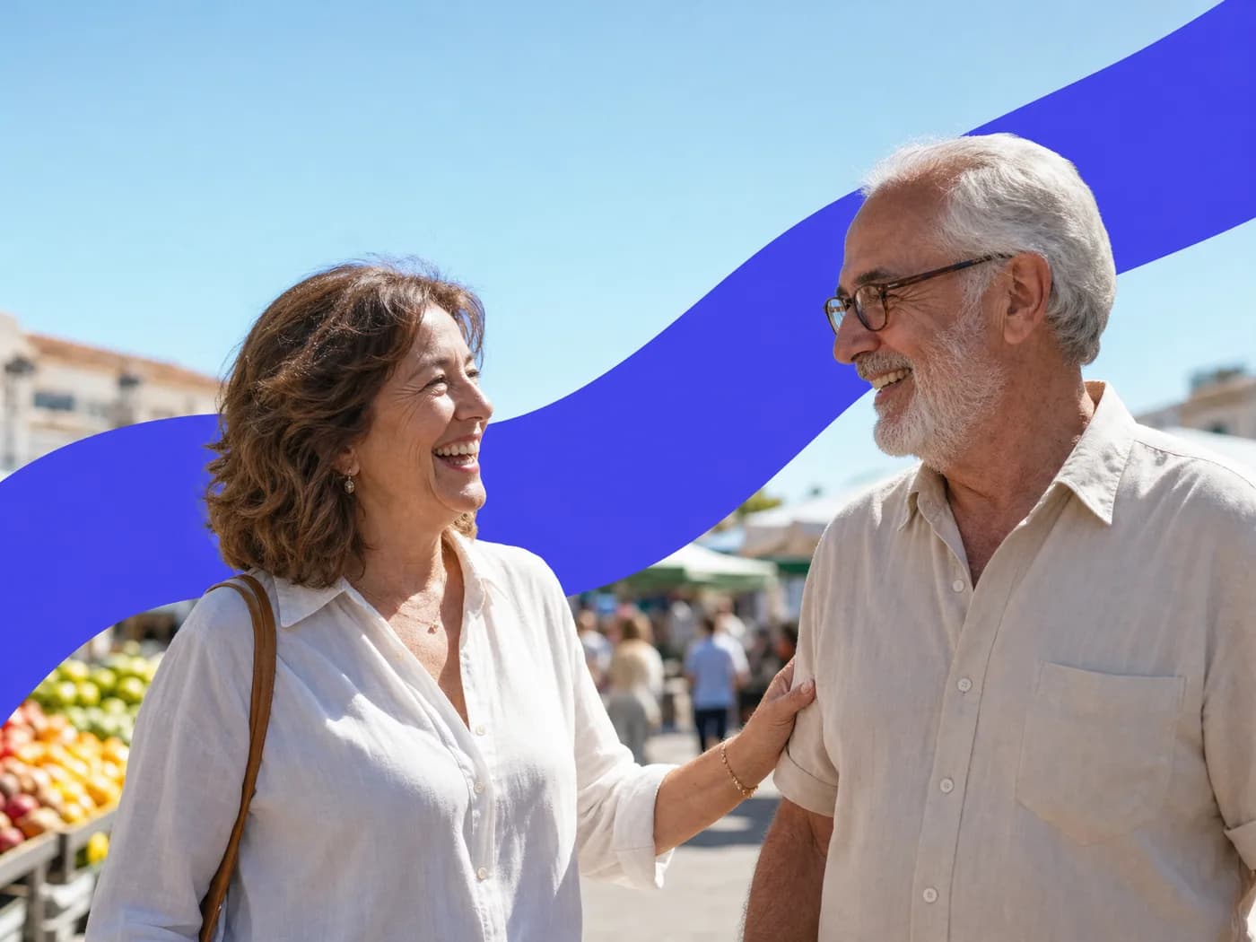 A woman laughing as she greets an older man at a sunny street market