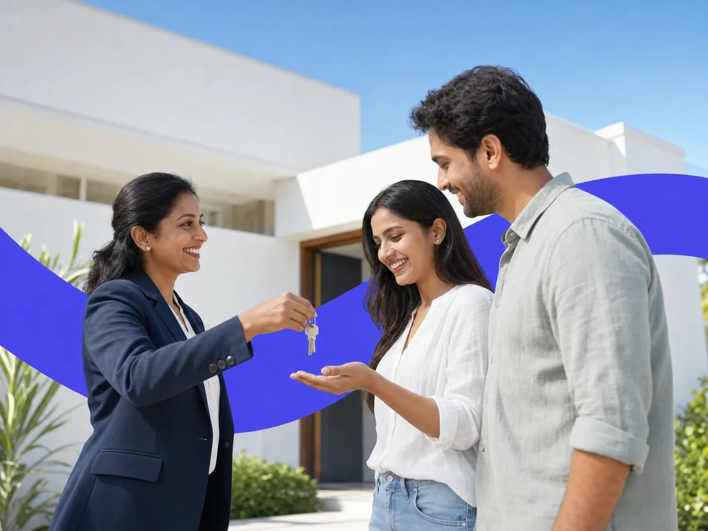 An estate agent handing house keys to a smiling young couple outside a white house